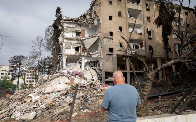 Les forces de sécurité et de secours israéliennes sur les lieux où un missile balistique iranien a frappé un immeuble, à Rehovot, le 15 juin 2025. (Crédit : Chaïm Goldberg/Flash90)