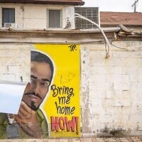 Une peinture murale en soutien aux otages détenus à Gaza est endommagée lors d'une frappe de missile iranien, à Rehovot, le 15 juin 2025. (Crédit : Chaïm Goldberg/Flash90)