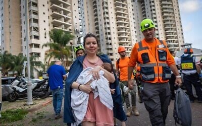 Les forces de sécurité et de secours israéliennes sur les lieux où un missile balistique tiré depuis l'Iran a frappé et causé des dégâts, à Petah Tikva, le 16 juin 2025. (Crédit : Chaïm Goldberg/Flash90)