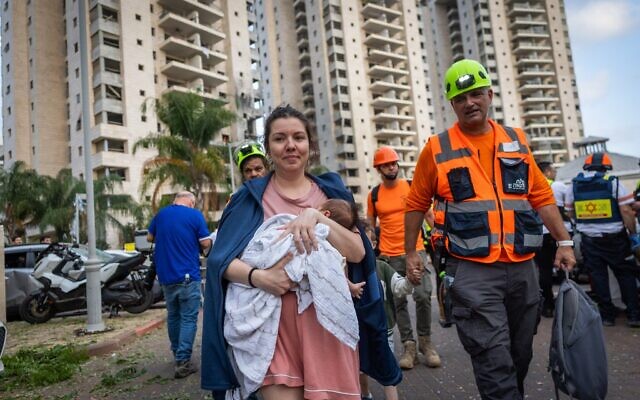 Les forces de sécurité et de secours israéliennes sur les lieux où un missile balistique tiré depuis l'Iran a frappé et causé des dégâts, à Petah Tikva, le 16 juin 2025. (Crédit : Chaïm Goldberg/Flash90)