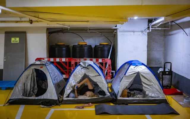 Des personnes réfugiées dans un parking souterrain à Tel Aviv en raison des attaques de missiles iraniennes, le 17 juin 2025. (Crédit : ChaÏm Goldberg/Flash90)