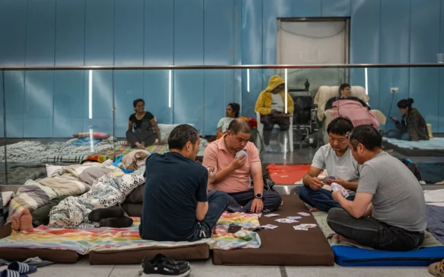 Un groupe d'hommes jouent aux cartes alors qu'ils s'abritent des attaques de missiles iraniens dans une station de métro souterraine dans le centre d'Israël, le 19 juin 2025. (Crédit : haim Goldberg/Flash90)