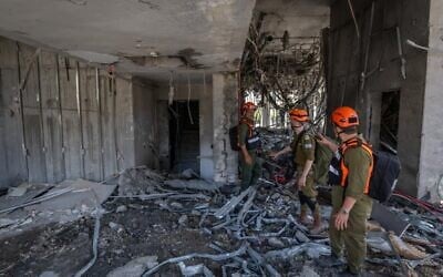 Les forces de sécurité et de secours israéliennes sur les lieux où un missile balistique tiré depuis l'Iran a frappé et causé des dégâts, à Ramat Gan, le 19 juin 2025. (Crédit : Chaïm Goldberg/Flash90)