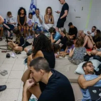 Les gens à l'abri alors que la sirène d'alerte annonce l'arrivée de missiles tirés depuis l'Iran, dans un abri antiatomique public, à Tel Aviv, le 20 juin 2025. (Crédit : Yehoshua Yosef/Flash90)