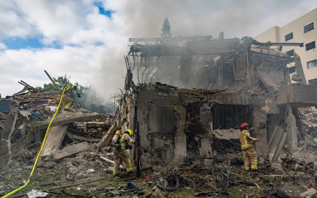 Les forces de sécurité et de secours israéliennes sur les lieux où un missile balistique tiré depuis l'Iran a frappé et causé des dégâts à Tel Aviv, le 22 juin 2025. (Crédit : Chaïm Goldberg/Flash90)