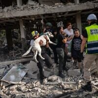 Les forces de sécurité et de secours israéliennes au point d'impact d'un missile balistique iranien à Tel Aviv, le 22 juin 2025. (Chaim Goldberg/ Flash90)