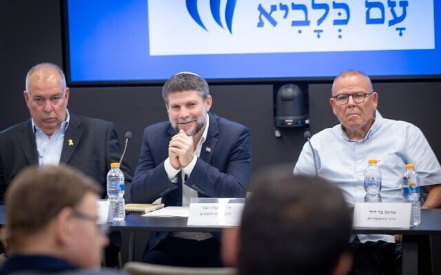 Le ministre des Finances Bezalel Smotrich, entouré du président du Présidium du secteur des affaires Dubi Amitaï (à gauche) et du chef de l'organisation syndicale de la Histadrout Arnon Bar-David (à droite), assistant à une conférence de presse, au ministère des Finances, à Jérusalem, le 23 juin 2025. (Crédit : Oren Ben Hakoon/FLASH90)
