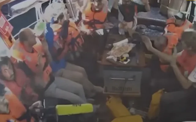 Des militants à bord du Madleen levant les mains dans une vidéo prise le 9 juin 2025. (Crédit : Capture d'écran : Al Jazeera/YouTube)