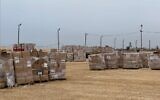 Des Palestiniens ramassent des cartons d'aide humanitaire sur un site de distribution géré par la Fondation humanitaire de Gaza, le 26 mai 2025. (Crédit : GHF)