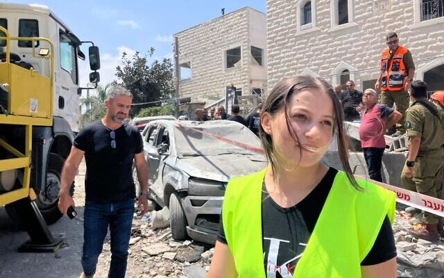 Doaa Hmade (à droite), bénévole auprès du Commandement du Front intérieur et de la municipalité de Tamra, se tient dans la rue où un missile balistique iranien a frappé une maison, tuant quatre femmes, le 15 juin 2025. (Diana Better/Times of Israel)