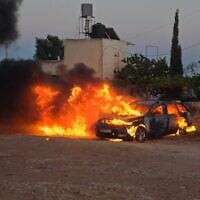 Un véhicule incendié lors d'une attaque menée par des résidents d’implantations contre le village palestinien d'al-Mughayyir, en Cisjordanie, le 25 juin 2025. (Crédit : Yesh Din)