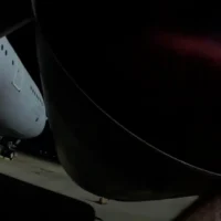 Un membre de Palestine Action pulvérise de la peinture rouge sur un avion à la base de la  Brize Norton de la Royal Air Force, le 20 juin 2025. (Capture d'écran)