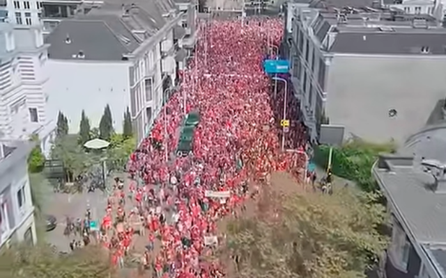 Photo d'Illustration : Des manifestants habillés de rouge dénoncent le "génocide" à Gaza à la Haye, aux Pays-Bas, le 18 mai 2025. (Capture d'écran : YouTube)