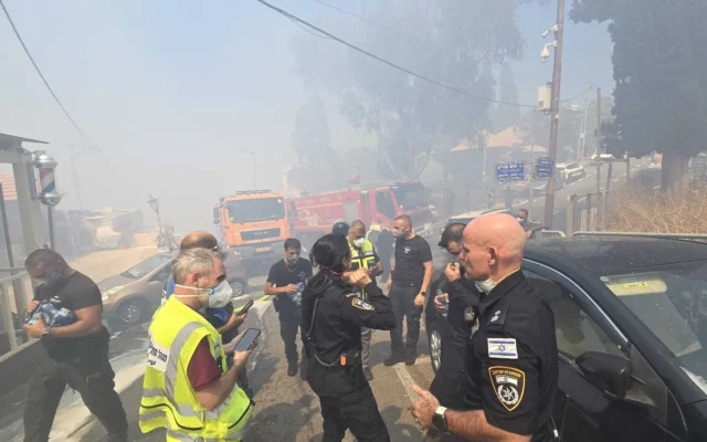 La police évacue des habitants du lieu où un incendie de forêt se développe dans le quartier de Halisa à Haïfa, le 29 juin 2025. (Crédit : Police israélienne) La police évacue des habitants du lieu où un incendie de forêt se développe dans le quartier de Halisa à Haïfa, le 29 juin 2025. (Crédit : Police israélienne)