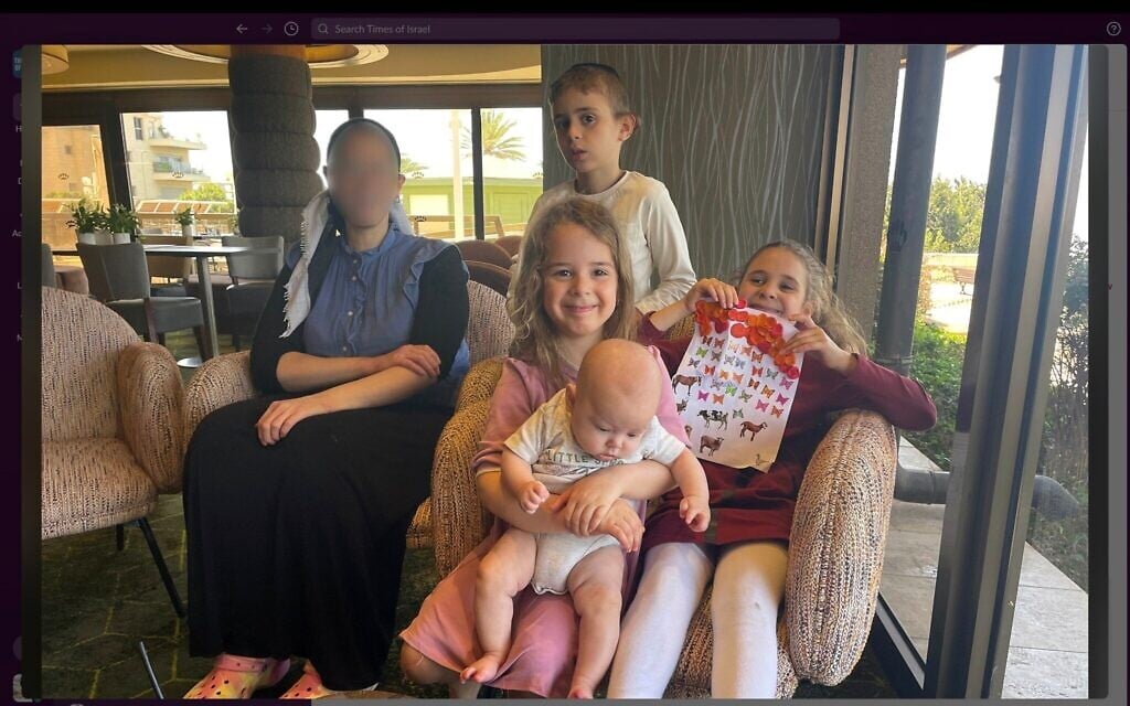 Une partie de la famille Rotstein dans un hôtel de la ville de Haïfa, dans le nord du pays, après la destruction de leur appartement lors d'une attaque de missiles iraniens le 15 juin 2025, photographiée le 16 juin 2025. Yehudit Rotstein (à gauche) a demandé à ce que son visage soit flouté. (Sue Surkes/Times of Israel)