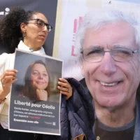 Une sympathisante tient une pancarte à l'effigie de Cécile Kohler, professeure de français détenue en Iran avec son compagnon Jacques Paris (à droite), lors d'un rassemblement en leur soutien à Paris, en France, le 14 mai 2023. (Crédit : Thomas SAMSON/AFP)
