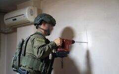 Un soldat de l'armée israélienne mesurant la maison d'un terroriste palestinien, en Cisjordanie, le 11 juillet 2025. (Crédit : Armée israélienne)