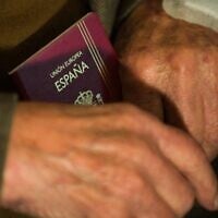 Illustration : Un homme tenant un passeport espagnol, le 9 juin 2009. (Crédit : Leon Neal/AFP)