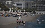Des touristes, sur la plage devant des hôtels sur l'île égéenne de Rhodes, en Grèce, le 29 août 2020. (Crédit : Louisa Gouliamaki/AFP)