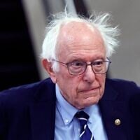 Le sénateur américain Bernie Sanders, du Vermont, marchant vers son bureau, au Capitole, à Washington, le 25 mars 2025. (Crédit : Kevin Dietsch/Getty Images/AFP)