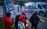 Des personnes tenant des bougies et des pancartes sur lesquelles on peut lire « Put Noem in Krome » (Mettez Noem à Krome) lors d'une veillée de protestation contre la détention et les expulsions massives menées par les services américains de l'Immigration and Customs Enforcement (ICE), devant le centre de détention de Krome, à Miami, le 24 mai 2025. (Crédit : Giorgio Viera/AFP)