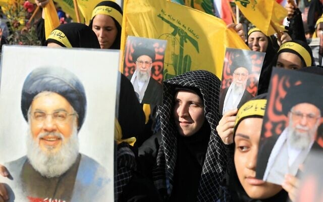 Des partisans du Hezbollah libanais brandissant des drapeaux et des photos de leur chef éliminé Hassan Nasrallah et du guide suprême iranien, l'ayatollah Ali Khamenei, lors d'un rassemblement devant l'ambassade d'Iran dans la banlieue sud de Beyrouth, pour célébrer le cessez-le-feu entre Israël et la République islamique, le 25 juin 2025. (Crédit : Haitham Moussawi/AFP)