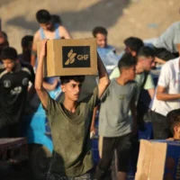 Des Palestiniens récupèrent des colis alimentaires dans un centre de distribution mis en place par la Gaza Humanitarian Foundation (GHF), une organisation privée, le 25 juin 2025. (Crédit : Eyad BABA / AFP)