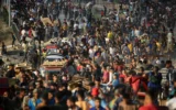 Des Palestiniens rassemblés à un point de distribution d'aide mis en place par la Gaza Humanitarian Foundation (GHF), une organisation privée, près du camp de réfugiés de Nuseirat, dans le centre de la bande de Gaza, le 25 juin 2025. (Crédit : Eyad Baba/AFP)