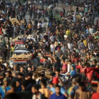 Des Palestiniens rassemblés à un point de distribution d'aide mis en place par la Gaza Humanitarian Foundation (GHF), une organisation privée, près du camp de réfugiés de Nuseirat, dans le centre de la bande de Gaza, le 25 juin 2025. (Crédit : Eyad Baba/AFP)
