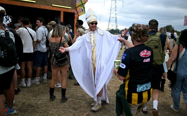 Un festivalier déguisé en pape amuse la foule lors du troisième jour du festival de Glastonbury, à Worthy Farm, dans le Somerset, le 27 juin 2025. (Crédit : Oli Scarff / AFP)