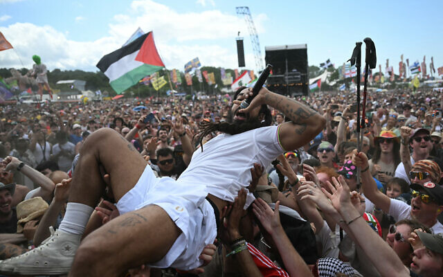 Bobby Vylan, du duo britannique Bob Vylan, se laisse porter par le public pendant sa performance sur la scène West Holts, au quatrième jour du festival de Glastonbury, à Worthy Farm, le 28 juin 2025. (Crédit : Oli Scarff/AFP)