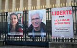 Les portraits de Cécile Kohler, actuellement emprisonnée en Iran, et de son compagnon Jacques Paris, ainsi qu'une pancarte indiquant "Liberté pour Cécile Kohler et Jacques Paris détenus arbitrairement en Iran depuis plus de deux ans dans des conditions épouvantables" devant le Palais Bourbon, l'Assemblée nationale française, à Paris, le 25 mars 2025. (Crédit : Bertrand Guay/AFP)