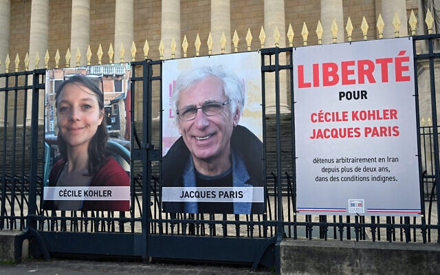 Les portraits de Cécile Kohler, actuellement emprisonnée en Iran, et de son compagnon Jacques Paris, ainsi qu'une pancarte indiquant "Liberté pour Cécile Kohler et Jacques Paris détenus arbitrairement en Iran depuis plus de deux ans dans des conditions épouvantables" devant le Palais Bourbon, l'Assemblée nationale française, à Paris, le 25 mars 2025. (Crédit : Bertrand Guay/AFP) Les portraits de Cécile Kohler, actuellement emprisonnée en Iran, et de son compagnon Jacques Paris, ainsi qu'une pancarte indiquant "Liberté pour Cécile Kohler et Jacques Paris détenus arbitrairement en Iran depuis plus de deux ans dans des conditions épouvantables" devant le Palais Bourbon, l'Assemblée nationale française, à Paris, le 25 mars 2025. (Crédit : Bertrand Guay/AFP)
