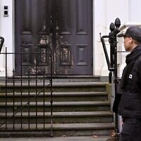 Un homme passant devant l'entrée principale incendiée de la synagogue East Melbourne, à Melbourne, le 6 juillet 2025. (Crédit : William West/AFP)