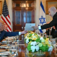 Le Premier ministre Benjamin Netanyahu remettant une lettre de recommandation au président américain Donald Trump lors de leur rencontre dans la Blue Room de la Maison Blanche, à Washington, le 7 juillet 2025. (Crédit : Andrew Caballero-Reynolds/AFP)