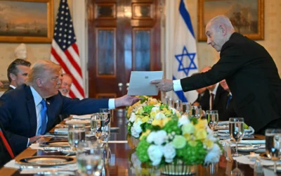 Le Premier ministre Benjamin Netanyahu remettant une lettre de recommandation au président américain Donald Trump lors de leur rencontre dans la Blue Room de la Maison Blanche, à Washington, le 7 juillet 2025. (Crédit : Andrew Caballero-Reynolds/AFP)