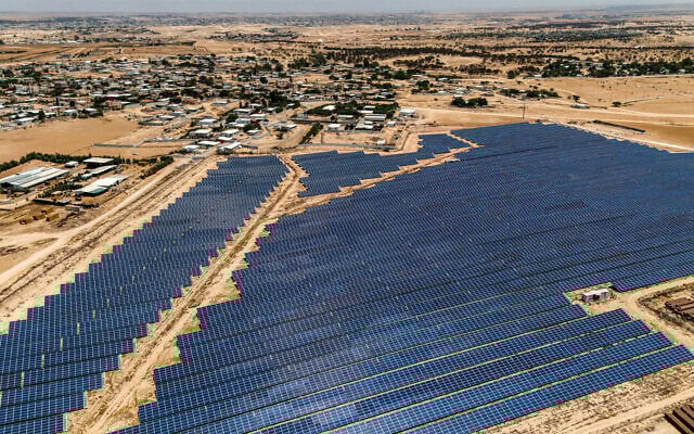 Vue aérienne des panneaux solaires dans une centrale de production d'électricité pour la communauté bédouine du village de Tirabin al-Sana, dans le sud du désert du Néguev en Israël, le 11 juin 2025. (Crédit : Menahem KAHANA / AFP)