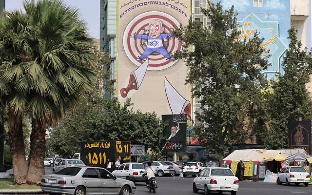 Une caricature anti-Israël se moquant du Premier ministre israélien Benjamin Netanyahu affichée sur la place de la Palestine, dans le centre-ville de Téhéran, le 13 juillet 2025. (Crédit : Atta Kenare/AFP)