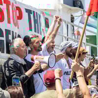 Des membres de l'équipage assistent au départ du bateau « Handala » de la flottille de la liberté pour Gaza dans un port de Syracuse, en Sicile, dans le sud de l'Italie, le 13 juillet 2025. Un bateau à destination de Gaza transportant des militants pro-palestiniens et de l'aide humanitaire a quitté la Sicile le 13 juillet 2025. (Crédit : Giovanni ISOLINO / AFP)