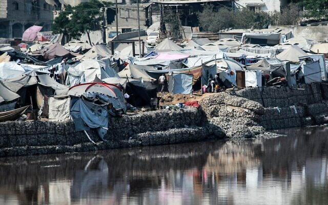 Des campements abritant des Palestiniens déplacés par le conflit près du bassin de collecte des eaux usées de Sheikh Radwan, qui approche de sa capacité de remplissage, dans la ville de Gaza le 14 juillet 2025. (Bashar TALEB / AFP)