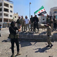 Les forces de sécurité syriennes posent pour une photo sur un rond-point de la ville de Sweida, à majorité druze, le 15 juillet 2025, à la suite d'affrontements entre des tribus bédouines et des combattants druzes. (Crédit : Sam HARIRI / AFP)
