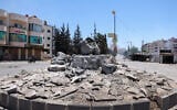 Des membres des forces de sécurité syriennes passent à moto devant un monument détruit dans la ville de Sweida, à majorité druze, le 15 juillet 2025, à la suite d'affrontements entre des tribus bédouines et des combattants druzes. (Crédit : Bakr ALKASEM / AFP)