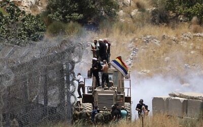 Des troupes israéliennes utilisent des gaz lacrymogènes pour disperser la foule alors que des civils druzes tentent de franchir la frontière syrienne sur le plateau du Golan, près de Majdal Shams, le 16 juillet 2025. (Crédit : Jalaa Marey / AFP)