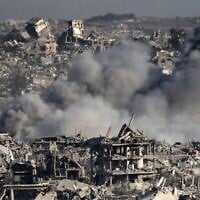 De la fumée s'élevant au-dessus de bâtiments détruits lors d'une frappe israélienne, sur une photo prise à la frontière israélienne avec la bande de Gaza le 17 juillet 2025. (Crédit : Jack Guez/AFP)