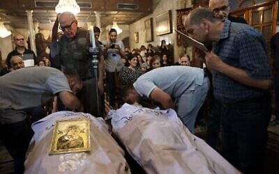 Des Palestiniens chrétiens font leurs adieux à Saad Salameh et Foumia Ayyad, tués  par un tir israélien errant qui a frappé l'église de la Sainte Famille dans la ville de Gaza, lors de leur cérémonie funéraire à l'église Saint Porphyrius le 17 juillet 2025. (Crédit : Omar al-Qattaa/AFP)