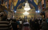 Des Palestiniens chrétiens assistent aux funérailles de Saad Salameh et Foumia Ayyad, tués lors d'une frappe israélienne sur l'église de la Sainte Famille dans la ville de Gaza. L'archevêque Alexios de l'église Saint Porphyrius dirige la messe, le 17 juillet 2025. (Crédit : Omar al-Qattaa/AFP)