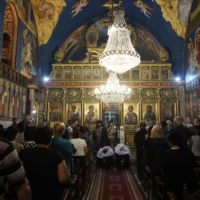 Des Palestiniens chrétiens assistent aux funérailles de Saad Salameh et Foumia Ayyad, tués lors d'une frappe israélienne sur l'église de la Sainte Famille dans la ville de Gaza. L'archevêque Alexios de l'église Saint Porphyrius dirige la messe, le 17 juillet 2025. (Crédit : Omar al-Qattaa/AFP)