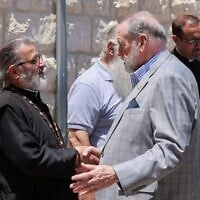 L'ambassadeur américain en Israël, Mike Huckabee (au centre), serrant la main du père Daoud Khoury, de l'Église grecque orthodoxe, lors de sa visite dans le village chrétien palestinien de Taybeh, en Cisjordanie, le 19 juillet 2025. (Crédit : Jaafar Aashtityeh/AFP)