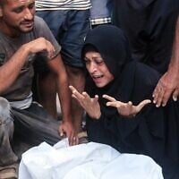 Une Palestinienne pleure un homme qui aurait été tué près d'un centre de distribution d'aides géré par la Fondation humanitaire de Gaza, une organisation soutenue par les Etats-Unis et Israël, à l'hôpital Nasser, le 19 juillet 2025 (Crédit : AFP).