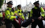 Un manifestant est emmené par des policiers lors d'une manifestation de soutien au groupe interdit Palestine Action, qui demande la levée de l'interdiction récemment imposée, à Parliament Square, dans le centre de Londres, le 19 juillet 2025 (Crédit : ARLOS JASSO / AFP)
